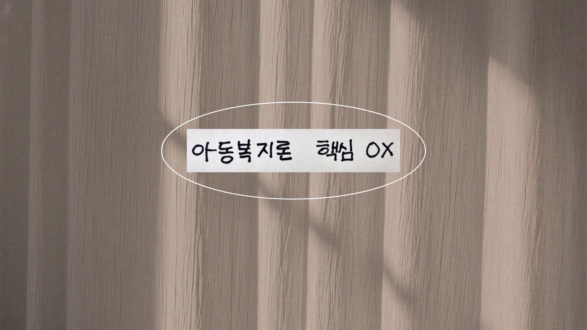 잔잔한 베이지색 커튼 배경 중앙에 '아동복지론 핵심 OX'라고 적힌 손글씨 종이 조각이 하얀색 타원형으로 강조되어 있습니다. 따뜻한 햇살이 비추고 있습니다.