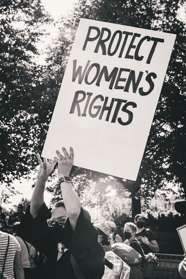 여성복지론 OX 퀴즈에 삽입된 여성의 권리를 보호하라는 피켓을 들고 서 있는 여성 이미지