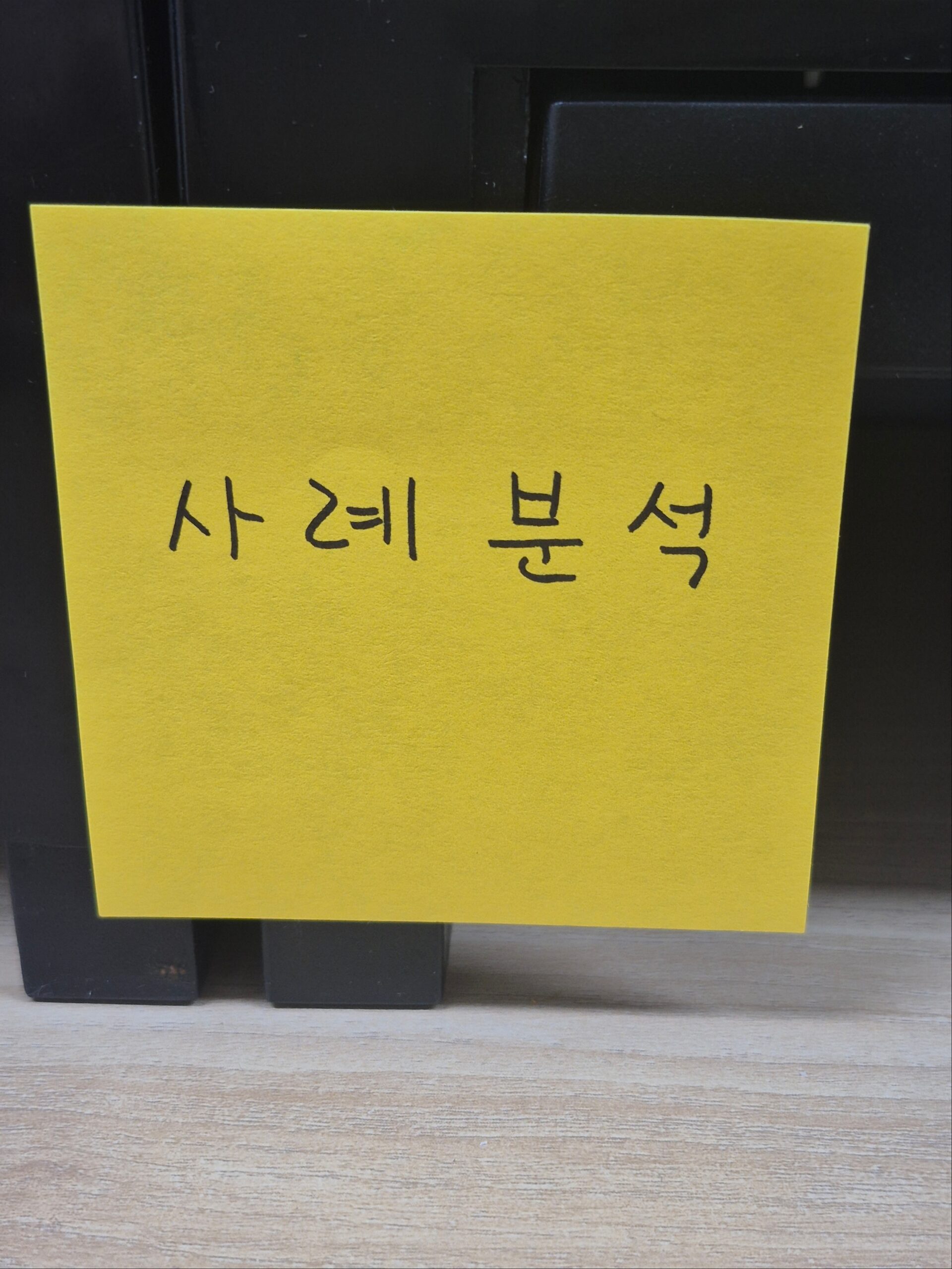 노란색 포스트잇에 '사례분석'이라고 직접 손글씨로 적혀 있는 이미지