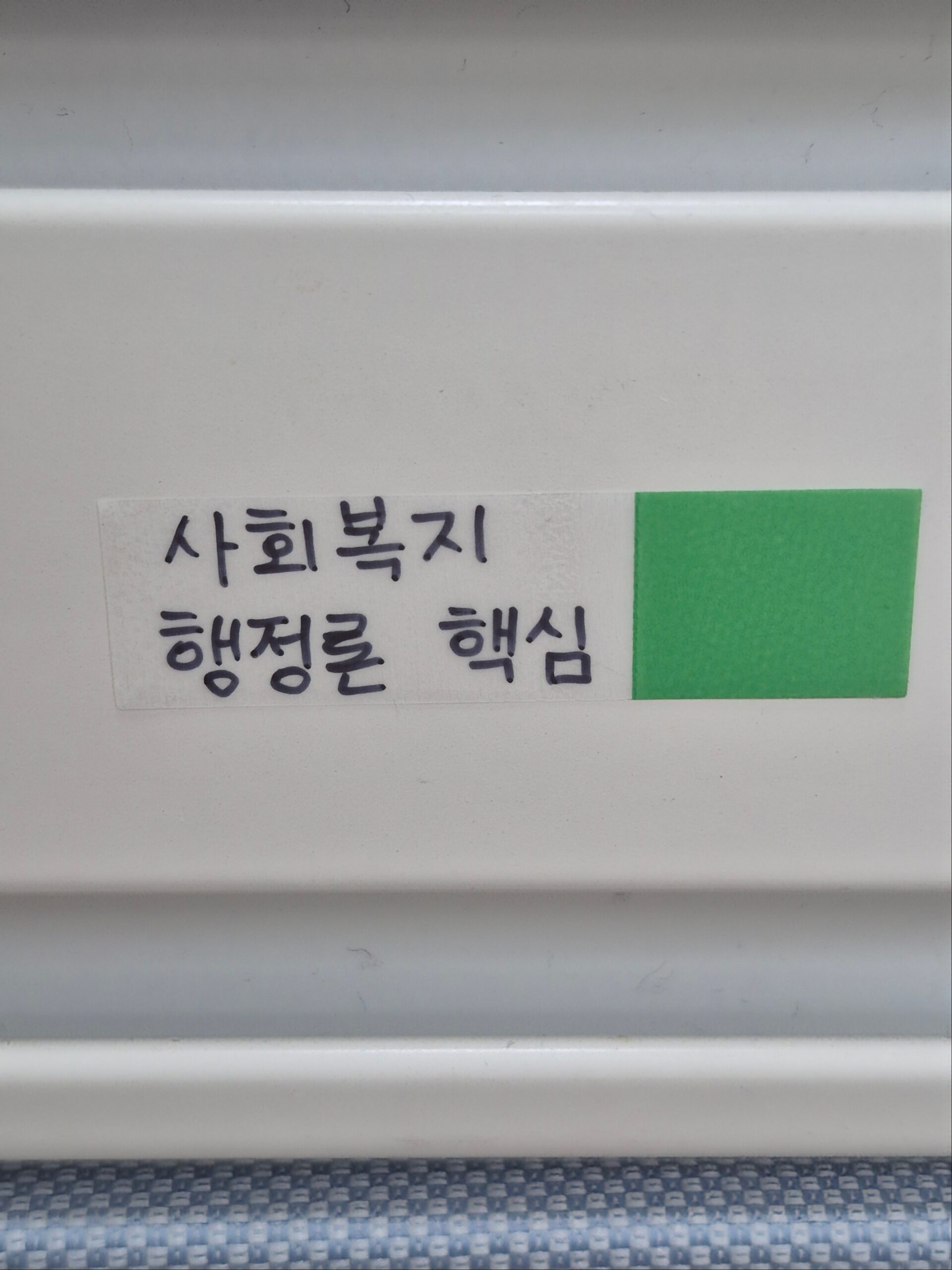 흰색 벽면에 초록색 포스트잇플래그에 검은색 글씨로 "사회복지행정론 핵심"이라고 적혀 있는 습